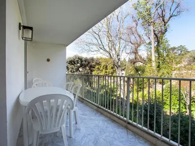 a balcony with a white table and chairs and a fence at Apartment Val Joli-2 by Interhome in Cannes