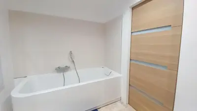 a white bathroom with a tub and a wooden door at Maison moderne centre-ville in Cannes