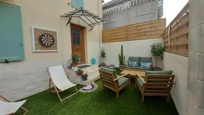 a patio with a wooden table and chairs and a table and chairs at Maison moderne centre-ville in Cannes