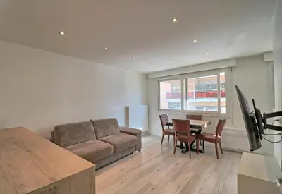a living room with a couch and a table and chairs at Appartement plein centre proche Palais et plages in Cannes