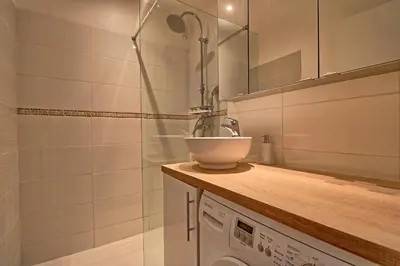 a bathroom with a sink and a washing machine at Appartement plein centre proche Palais et plages in Cannes