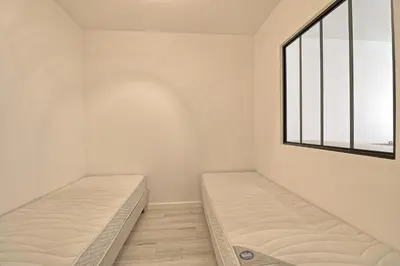two beds in a room with a window at Appartement plein centre proche Palais et plages in Cannes