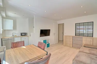 a kitchen and living room with a table and chairs at Appartement plein centre proche Palais et plages in Cannes