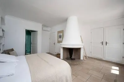 a white bedroom with a bed and a fireplace at Villa Palma near the beaches Cannes in Cannes