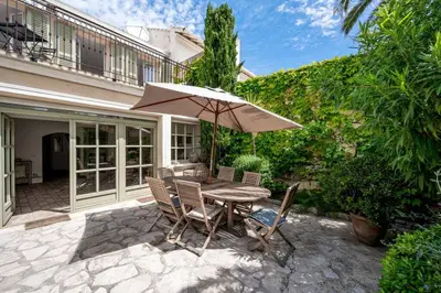 a table and chairs with an umbrella on a patio at Villa Palma near the beaches Cannes in Cannes