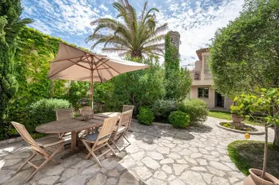 a table and chairs with an umbrella on a patio at Villa Palma near the beaches Cannes in Cannes