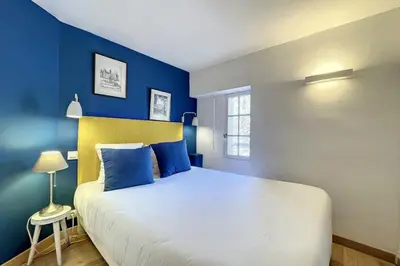 a bedroom with a large bed with blue walls at 1 Bedroom Ideal Location Cannes in Cannes