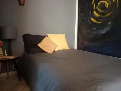 a bedroom with a bed with a painting on the wall at STUDIO VILLA VIANNEY in Cannes
