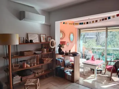 a living room with a table and a window at STUDIO VILLA VIANNEY in Cannes