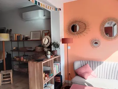 a living room with a couch and mirrors on the wall at STUDIO VILLA VIANNEY in Cannes