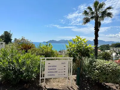 a sign in a garden with a palm tree at Villa FRANCIA bat Van Gogh in Cannes