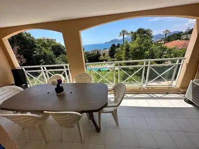 a dining room with a table and chairs on a balcony at Villa FRANCIA bat Van Gogh in Cannes