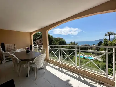 a balcony with a table and chairs and a large window at Villa FRANCIA bat Van Gogh in Cannes