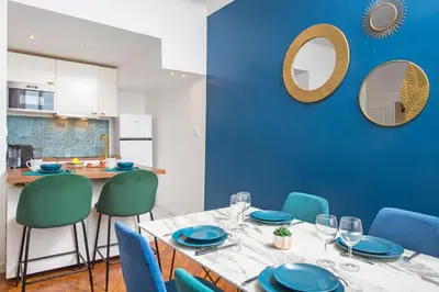 a dining room with a table and blue chairs at 5mn Palais des festivals - Vue sur le Port - BS in Cannes