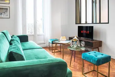 a living room with a green couch and a table at 5mn Palais des festivals - Vue sur le Port - BS in Cannes