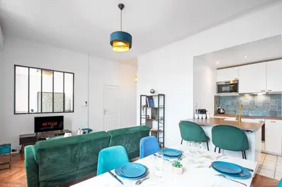 a living room with two tables and a green couch at 5mn Palais des festivals - Vue sur le Port - BS in Cannes