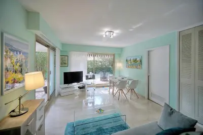 a living room with a couch and a table at Immogroom - Quiet T2 - Garden level - AC - Wifi in Cannes