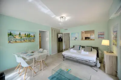a bedroom with a bed and a table and chairs at Immogroom - Quiet T2 - Garden level - AC - Wifi in Cannes