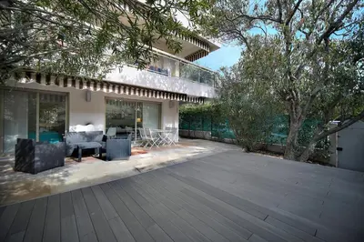 an outdoor patio with a deck and a house at Immogroom - Quiet T2 - Garden level - AC - Wifi in Cannes