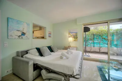 a bedroom with a bed and a large window at Immogroom - Quiet T2 - Garden level - AC - Wifi in Cannes