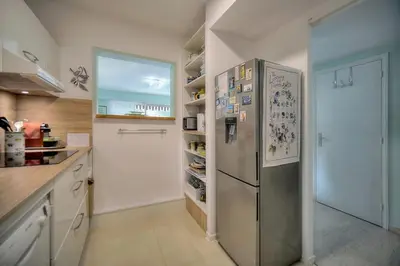 a kitchen with a stainless steel refrigerator with magnets at Immogroom - Quiet T2 - Garden level - AC - Wifi in Cannes