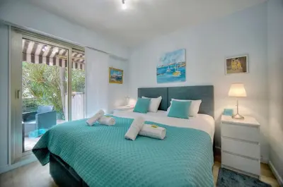 a bedroom with two beds and a large window at Immogroom - Quiet T2 - Garden level - AC - Wifi in Cannes