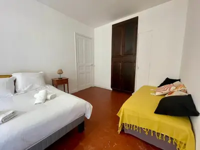 a bedroom with a white bed and a yellow blanket at Le Zeus - Cannes Villa St Henri seafront unique 2bedrooms in Cannes