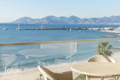 a table and chairs on a beach with the ocean at Cannes appart 3 chambres luxe - Impératrice in Cannes