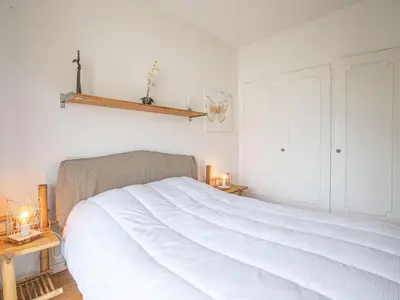 a bedroom with a large white bed with two tables at Apartment Les Aliscamps by Interhome in Cannes