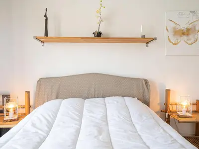 a bedroom with a white bed with two tables and two lamps at Apartment Les Aliscamps by Interhome in Cannes
