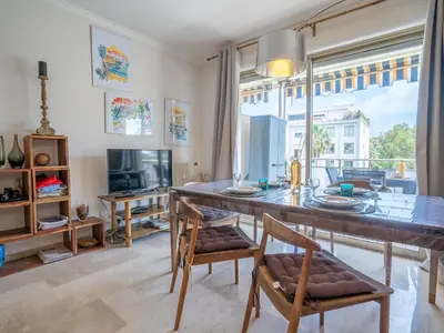 a dining room with a large wooden table and chairs at Apartment Les Aliscamps by Interhome in Cannes