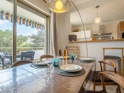 a dining room with a large wooden table and chairs at Apartment Les Aliscamps by Interhome in Cannes