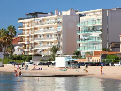 a group of people on a beach with a building at Apartment Cannes Bay-2 by Interhome in Cannes