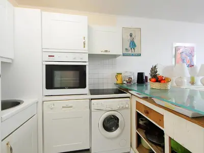 a white kitchen with a washer and dryer at Apartment Cannes Bay-2 by Interhome in Cannes