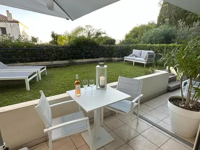 a white table and chairs with wine bottles and glasses at Résidence PARADIS BLEU - Appt 3P in Cannes