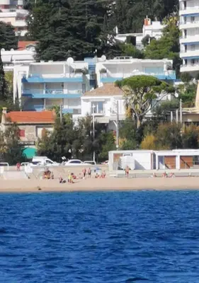 a group of people on a beach with buildings at Résidence PARADIS BLEU - Appt 3P in Cannes