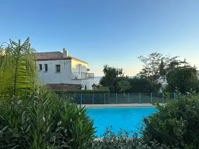 a villa with a swimming pool and a house at Résidence PARADIS BLEU - Appt 3P in Cannes