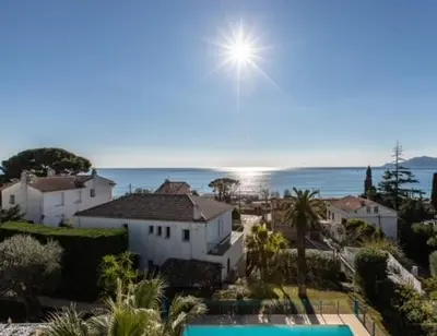 a view of a house with a pool and the ocean at Résidence PARADIS BLEU - Appt 3P in Cannes