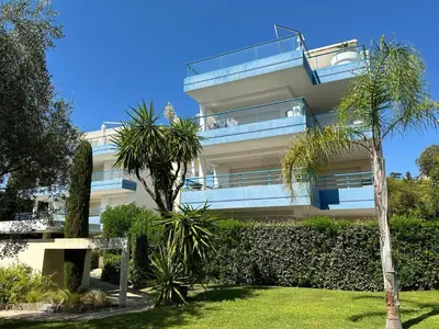 a apartment building with a balcony and palm trees at Résidence PARADIS BLEU - Appt 3P in Cannes
