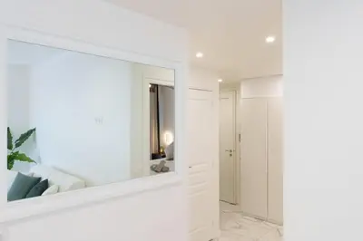 a large mirror in a white room with a bathroom at Le Maubourg - Hypercentre - 150m Croisette - AC in Cannes