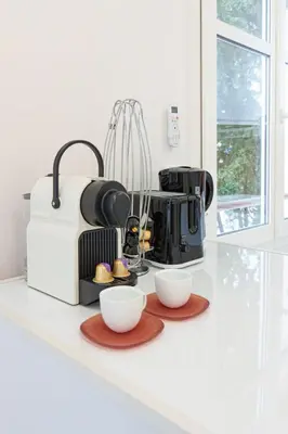 a coffee maker and two cups on a kitchen counter at Le Maubourg - Hypercentre - 150m Croisette - AC in Cannes