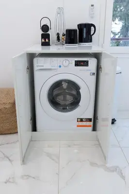a washing machine in a cabinet in a kitchen at Le Maubourg - Hypercentre - 150m Croisette - AC in Cannes