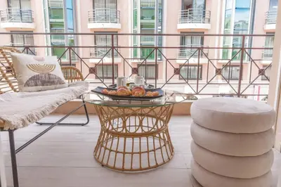 a balcony with a table with a bowl of food on it at Le Maubourg - Hypercentre - 150m Croisette - AC in Cannes