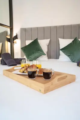 a tray with food and drinks on a bed at Le Joffre - Hypercentre - 200m Palais - AC in Cannes