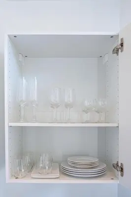 a cupboard with plates and wine glasses in it at Le Joffre - Hypercentre - 200m Palais - AC in Cannes