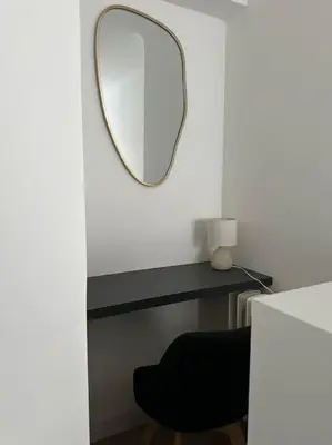 a mirror sitting on a table with a black chair at Joli F2, 7 min de la gare in Cannes