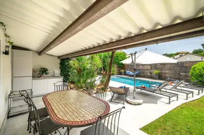 a patio with a table and chairs and a swimming pool at CANNES VILLA: 15 mins walk to beach & centre in Cannes