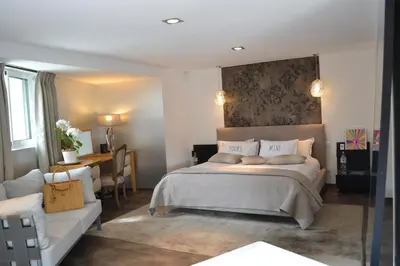 a bedroom with a bed and a table and a couch at CANNES VILLA: 15 mins walk to beach & centre in Cannes