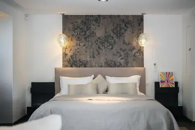 a bedroom with a large bed with a large headboard at CANNES VILLA: 15 mins walk to beach & centre in Cannes