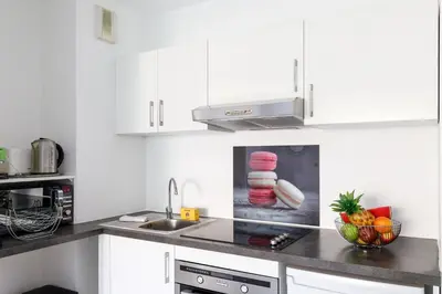 a kitchen with white cabinets and a bowl of fruit on the counter at Fleury Home YourHostHelper in Cannes